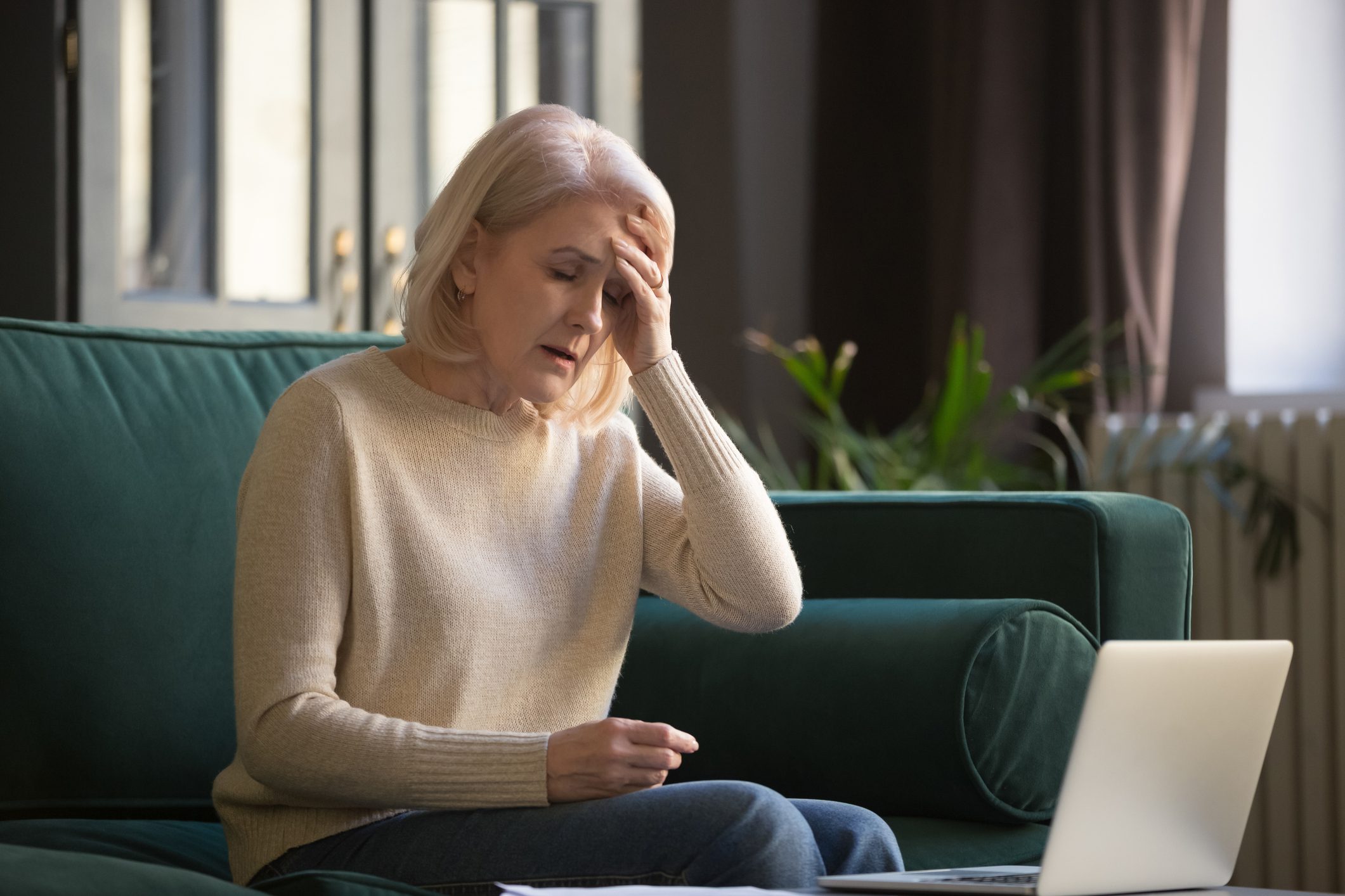 Woman stressed while looking at laptop